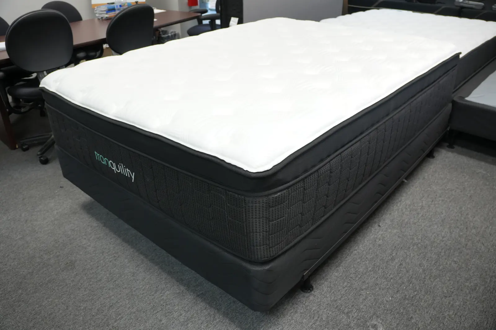 White pillow-top mattress on a dark base in the Golden Mattress showroom