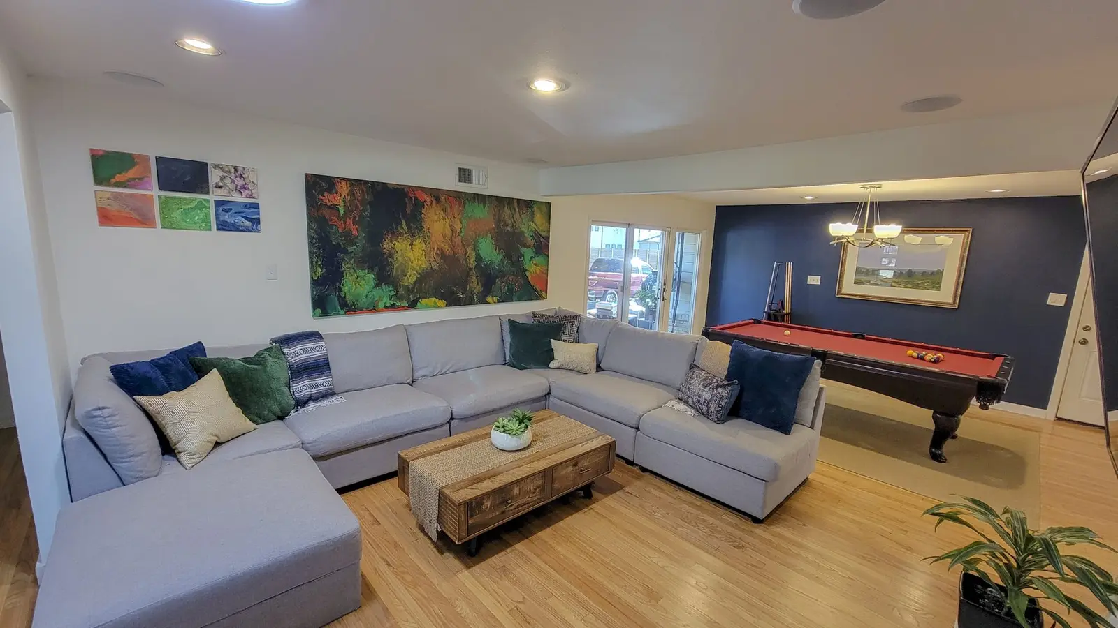 Living room at The McCosh House with a large gray sectional, a fireplace and a pool table
